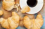 croissants and cup of coffee on grunge painted wood