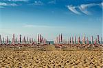 withdrawn yellow umbrellas and sunlongers on the sandy beach in Italy