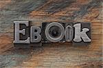 ebook word in vintage letterpress metal type on a grunge painted wood background