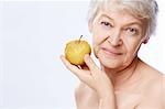 Elderly woman with an apple on a white background
