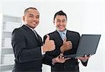 Southeast Asian business people thumbs up, holding notebook in workplace