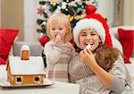 Happy mother and baby eating Christmas cookies