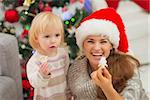 Smiling mother and baby eating Christmas cookies