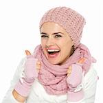 Smiling woman in knit scarf, hat and mittens showing thumbs up