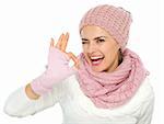 Smiling woman in knit winter clothes showing ok gesture