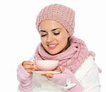 Happy young woman in knit winter clothing enjoying cup of hot tea