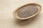 chia seeds in a rustic oval wood bowl against canvas