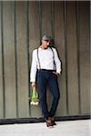 Man Leaning Against Wall Holding Flowers, Mannheim, Baden-Wurttemberg, Germany