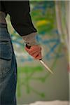 Close-up of Young Man Holding Knife with Graffiti in Background, Mannheim, Baden-Wurttemberg, Germany