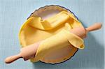 Overhead View of Pie Crust in Pie Plate and Rolling Pin on Blue Background, Studio Shot