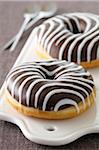 Close-up of Chocolate Dipped Donut with Vanilla Stripes on Cutting Board, Studio Shot