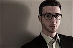 Head and Shoulder Portrait of Young Man wearing Glasses, Looking at Camera, Studio Shot