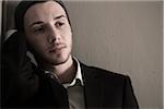 Portrait of Young Man wearing Woolen Hat and Suit Jacket, Looking to the Side, Absorbed in Thought, Studio Shot