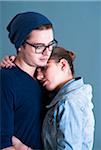 Portrait of Young Couple Embracing, Studio Shot on Blue Background