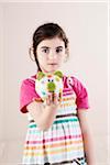 Portrait of Girl holding Piggy Bank in Studio