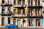 Blue Classic Car Driving Past Residential Apartment Buildings, Havana, Cuba