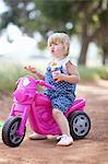 Toddler girl sitting on toy motorcycle