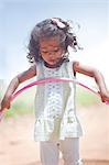 Girl playing with hula hoop outdoors