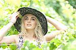 Woman wearing sun hat in tall plants