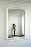 Nude woman reflected in mirror