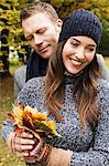 Couple holding autumn leaves