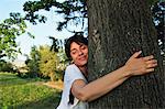 Woman hugging tree in forest