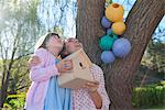 Mother and daughter holding birdhouse