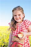 Girl eating sack of apples outdoors