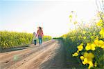 Mother and daughter walking on dirt road