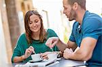 Couple having coffee at sidewalk cafe