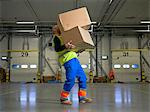 Worker carrying boxes in warehouse