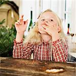 Girl eating Christmas cookies in kitchen