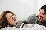Couple laughing together on bed