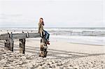 Woman on abandoned pier on beach