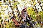 Couple riding bicycle in forest