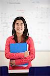 Student holding book in classroom