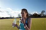 Girl drinking water in field