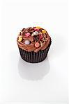 A chocolate cupcake decorated with chocolate beans