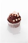 A chocolate cupcake decorated with chocolate sticks