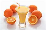 An orange smoothie and fresh oranges