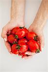 A woman's hands holding fresh tomatoes