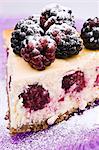 A slice of cheesecake with blackberries (close-up)