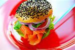 A poppyseed roll filled with salmon, onions and salad