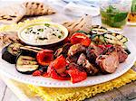 Grill platter with lamb, peppers, aubergines, courgettes, a hummus dip and pita bread