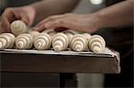 Hands sorting unbaked croissants