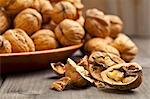 Whole and halved walnuts on a wooden table