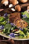 Roast venison filled with mushrooms on a bed of lettuce