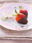 Chocolate strawberries on a pink, floral-patterned plate