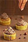 Cupcakes being decorated with sweet bean cream and caramelised nuts