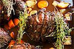 Roast venison with root vegetables and thyme in a pan